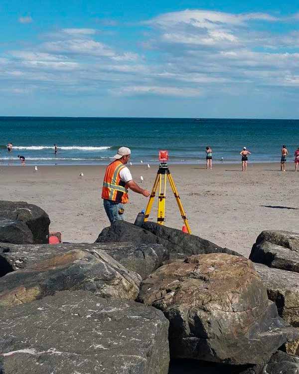Promised Land Survey surveyor on the beach with equipment